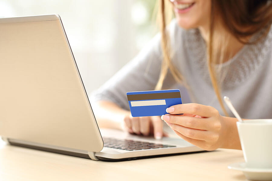 a young woman makes a purchase online after learning how a secured credit card works