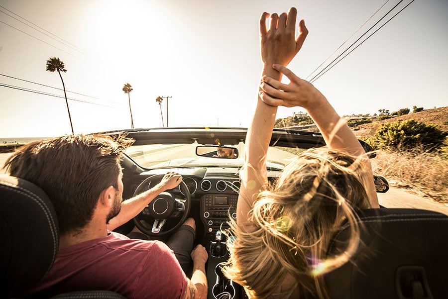 a carefree couple take a ride in their new convertible after choosing an auto loan lender in San Jose, CA