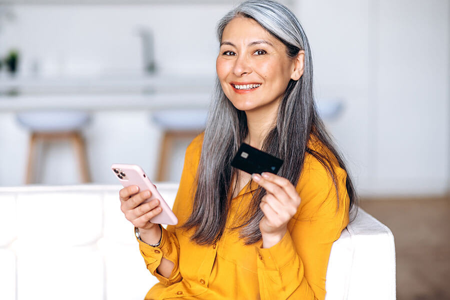 A woman confidently makes an online purchase with her credit card after learning about the different types of credit cards.
